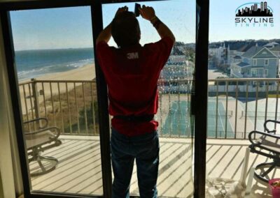 installer working on apartment patio doors overlooking the beach