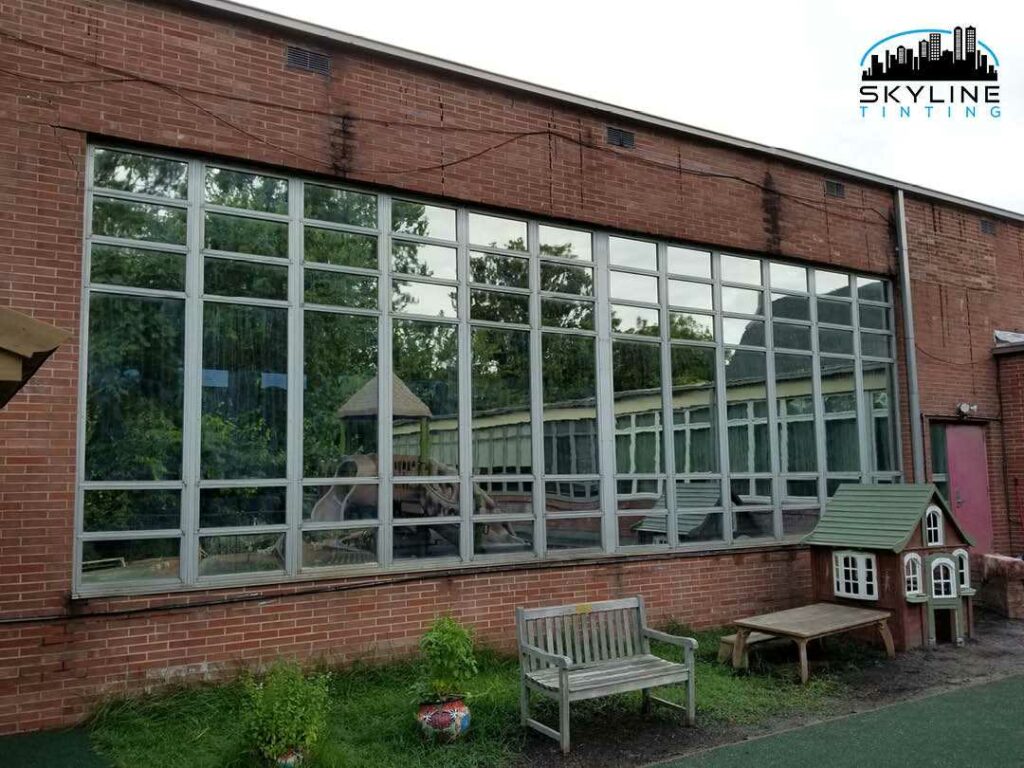 reflective mirror tint installed on windows of a red brick building