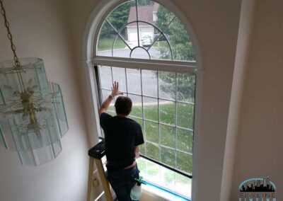 large two piece foyer window in home with tint being installed