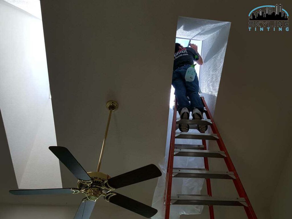 installer up into a skylight tunnel installing tint