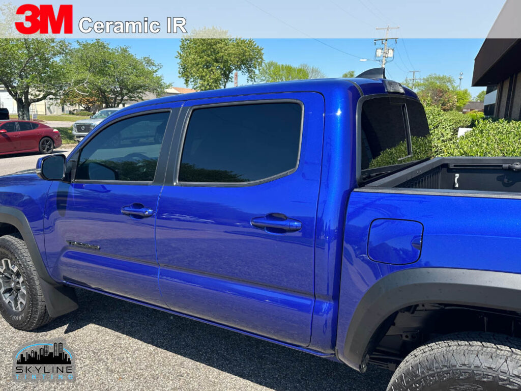 rear 3/4 view of blue four door pickup with dark tinted windows