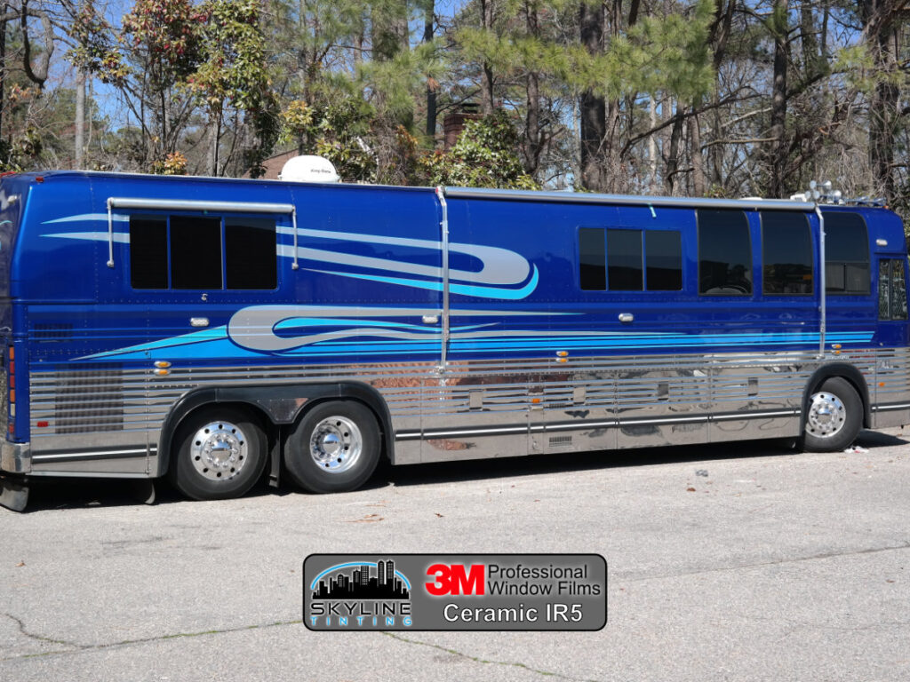 large blue and silver bus rv with dark tinted windows