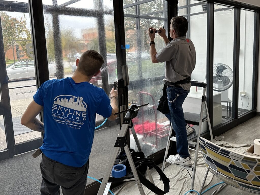 Skyline Tinting technicians installing 3M Ultra S800 security window film with Pentagon Protection frame attachment at WVEC TV13 in Norfolk, VA
